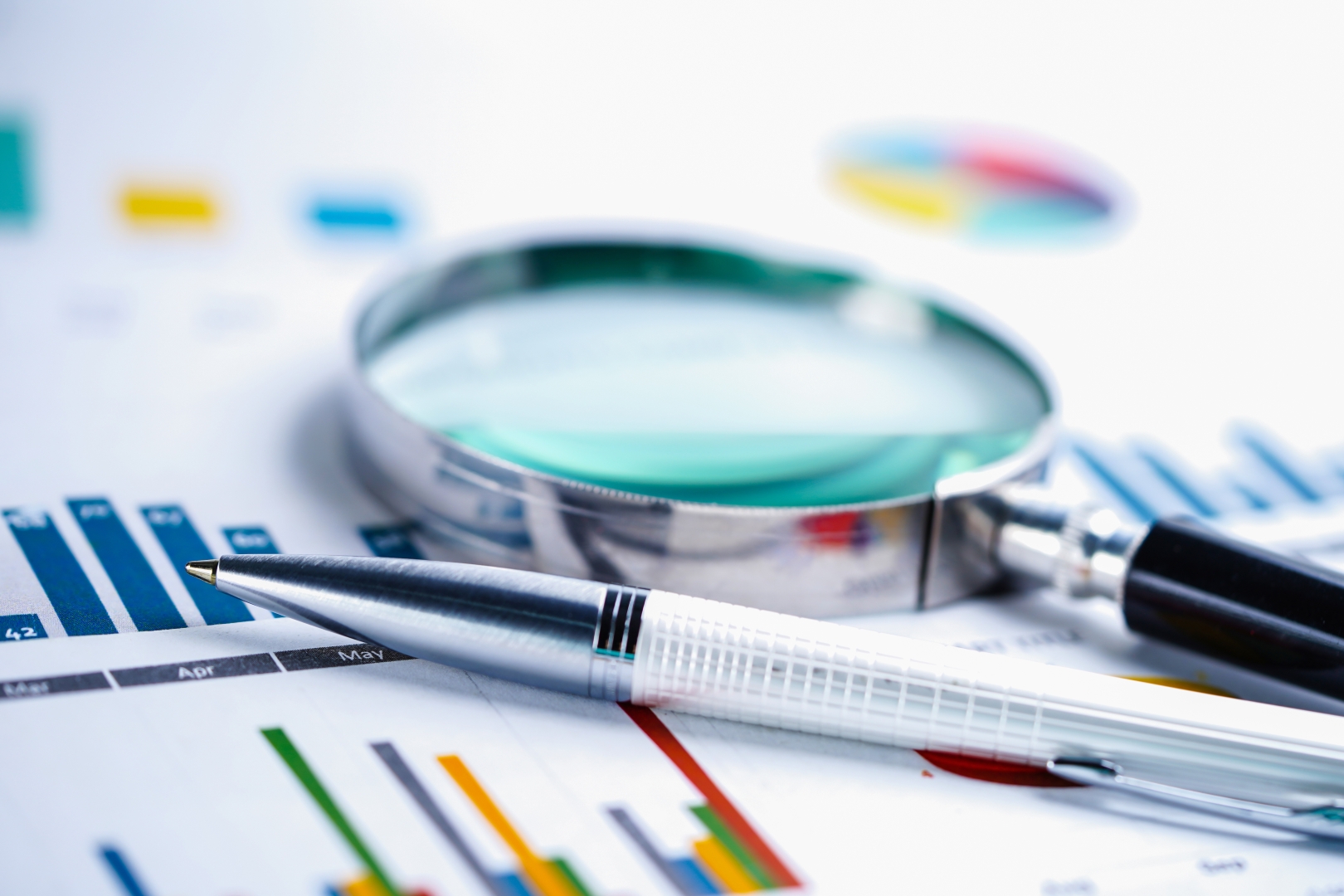 Research documents and a magnifying glass used for analysis.